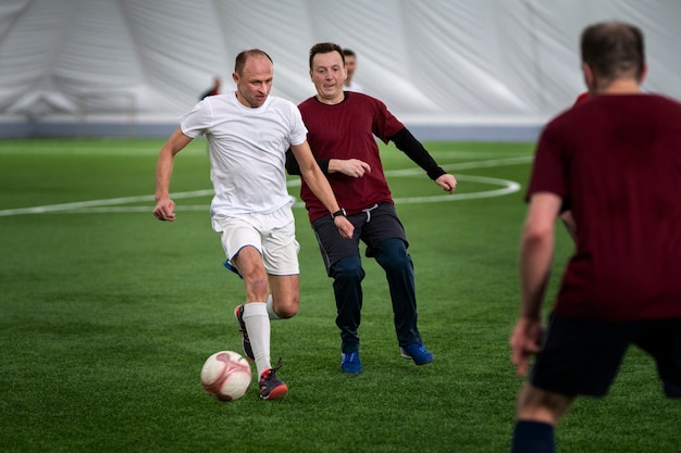 Foto gratuita hombres de tiro completo jugando al fútbol