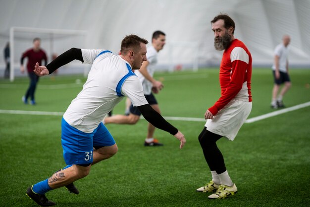 Hombres de tiro completo jugando al fútbol