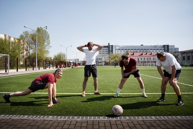 Hombres de tiro completo que se estiran antes del juego