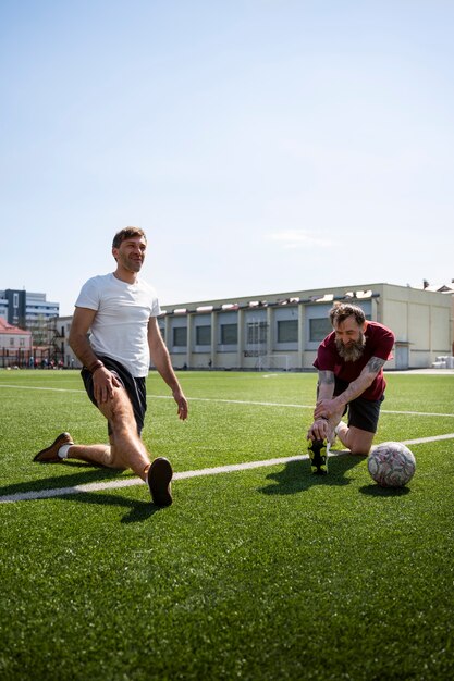 Hombres de tiro completo que se estiran antes del juego