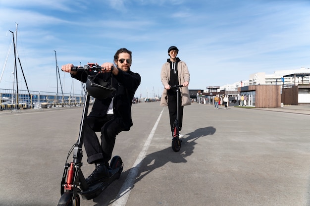 Hombres de tiro completo en scooters eléctricos.