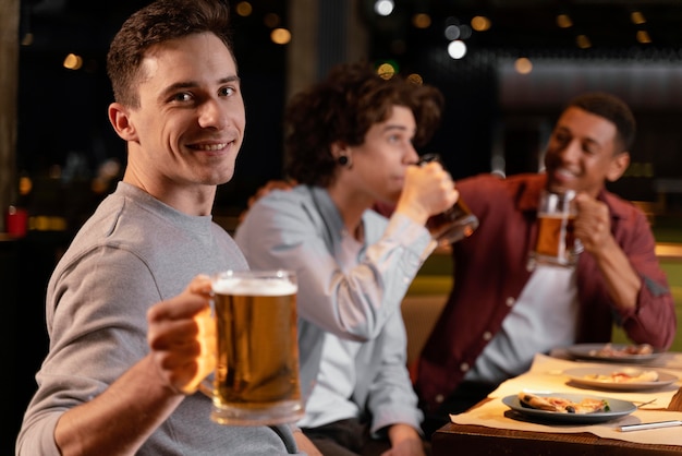 Hombres de tiro medio bebiendo cerveza