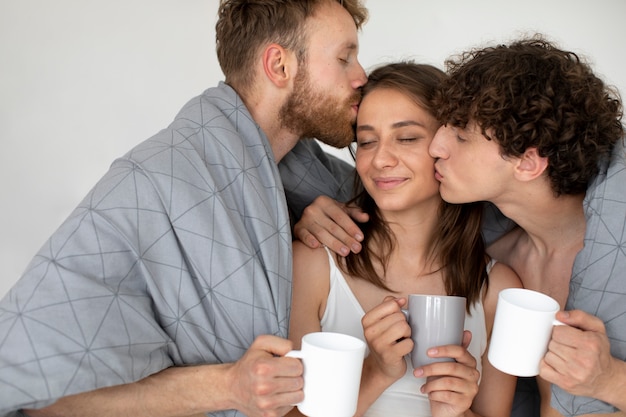 Foto gratuita hombres de tiro medio besando a mujer