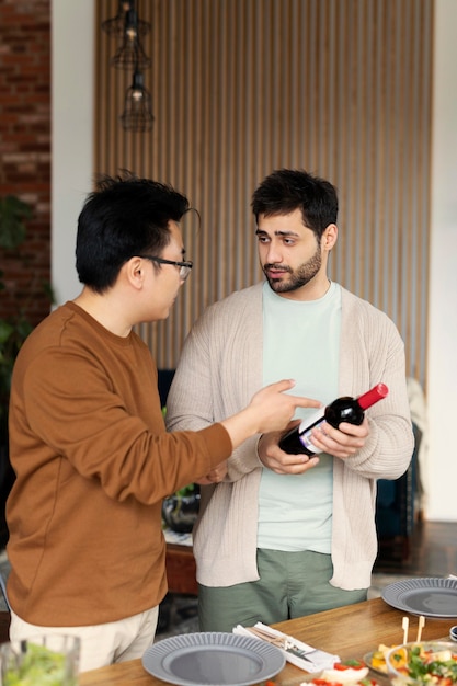 Hombres de tiro medio con botella de vino