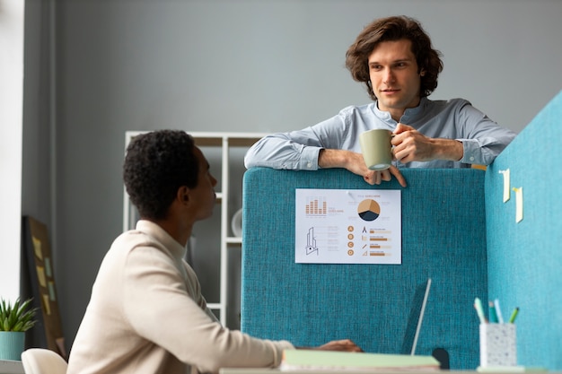 Foto gratuita hombres de tiro medio hablando en el trabajo