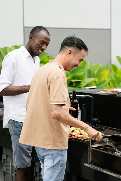 Hombres de tiro medio haciendo barbacoa