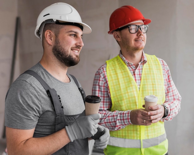 Hombres de tiro medio sosteniendo café