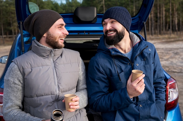 Hombres de tiro medio sosteniendo tazas