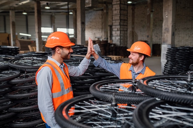 Foto gratuita hombres trabajando junto a un montón de ruedas.