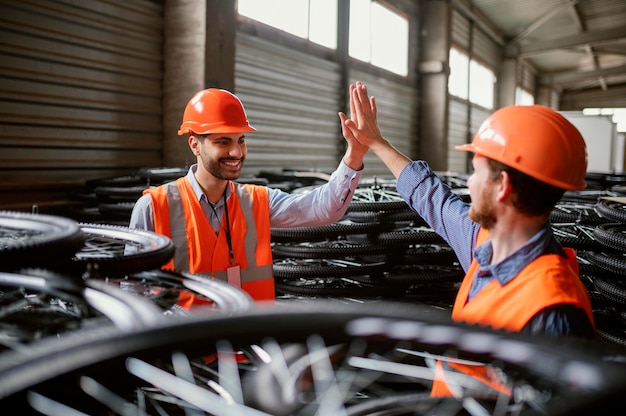 Foto gratuita hombres trabajando junto a un montón de ruedas.