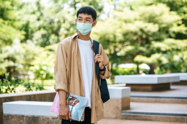 Los hombres usan máscaras, llevan libros y llevan una mochila en las escaleras.