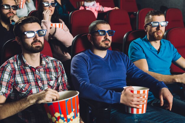 Hombres viendo películas en el cine