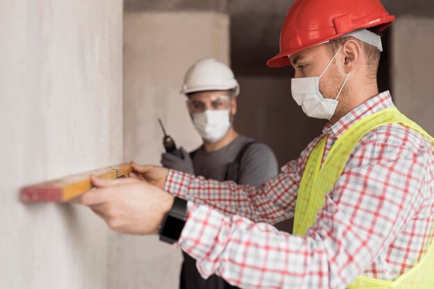 Hombres de vista lateral trabajando con máscaras