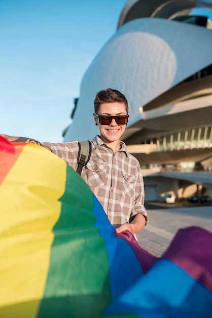 Foto gratuita homosexual con bandera de arcoiris volando