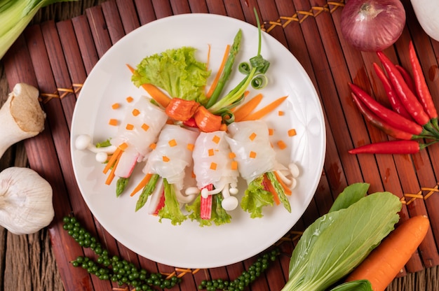 Hongos, zanahorias, espárragos y lechuga atados con fideos