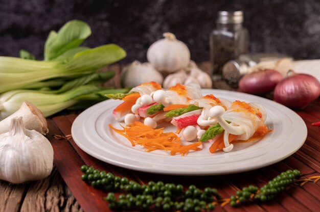 Hongos, zanahorias, espárragos y lechuga atados con fideos