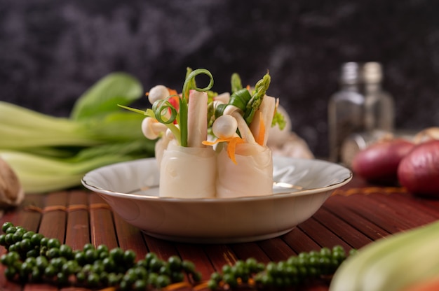 Foto gratuita hongos, zanahorias, espárragos y lechuga atados con fideos