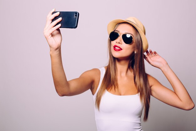 Hora de hacerse un selfie. Mujeres jóvenes alegres haciendo selfie por su teléfono inteligente