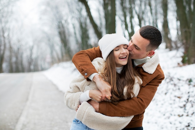 Hora de invierno pareja sonriente de tiro medio