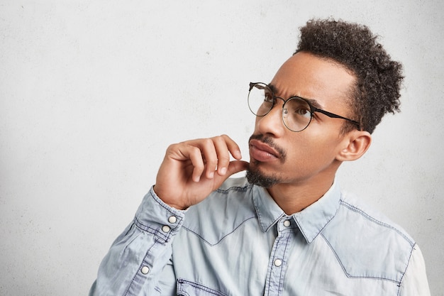 Foto gratuita horizontal retrato de empresario con peinado afro, barba y bigote, lleva gafas