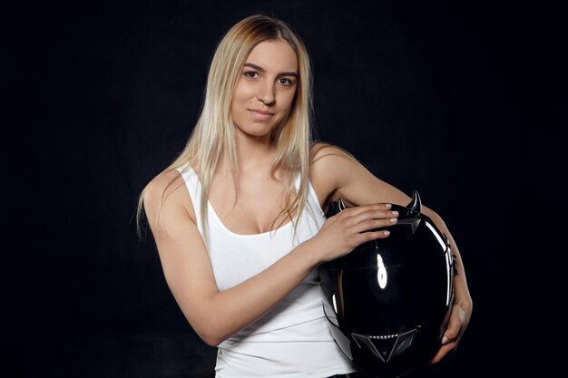 Horizontal retrato de positivo joven atlético europeo femenino con cabello teñido vistiendo camiseta blanca sin mangas