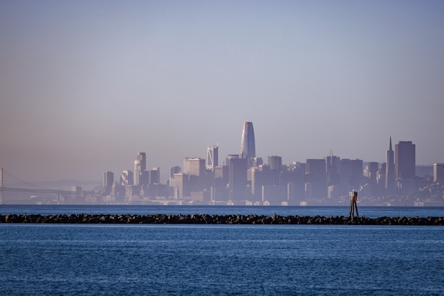 Horizonte de la ciudad a través del cuerpo de agua durante el día.