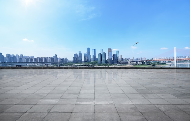 Horizonte panorámico y edificios con suelo cuadrado concreto vacío