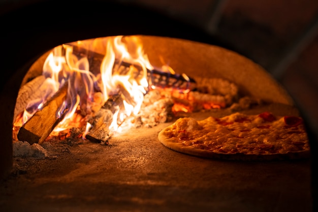 Foto gratuita hornear pizza en horno de leña