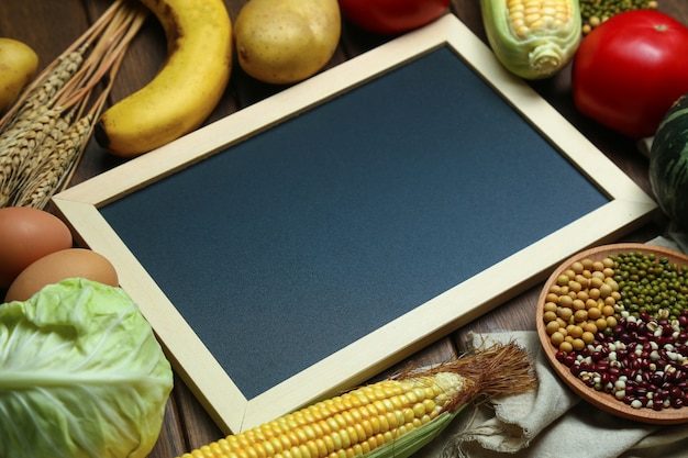 Foto gratuita hortalizas orgánicas frescas, frutas, huevos, frijoles y granos con pizarra en mesa de madera de época