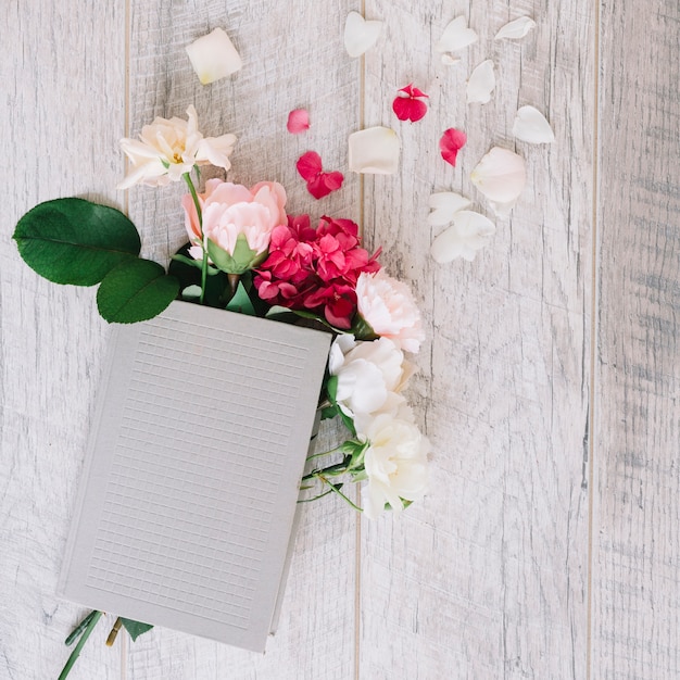 Hortensia y rosas en el diario sobre tabla de madera.