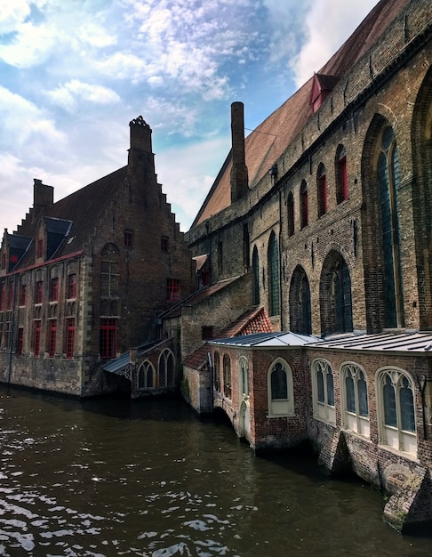 Hospital de San Juan rodeado de agua bajo la luz del sol en Brujas en Bélgica