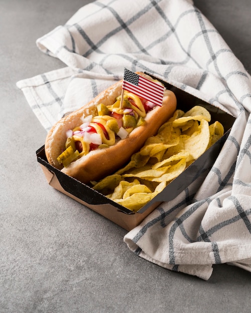 Hot-dog de alto ángulo y patatas fritas con bandera americana