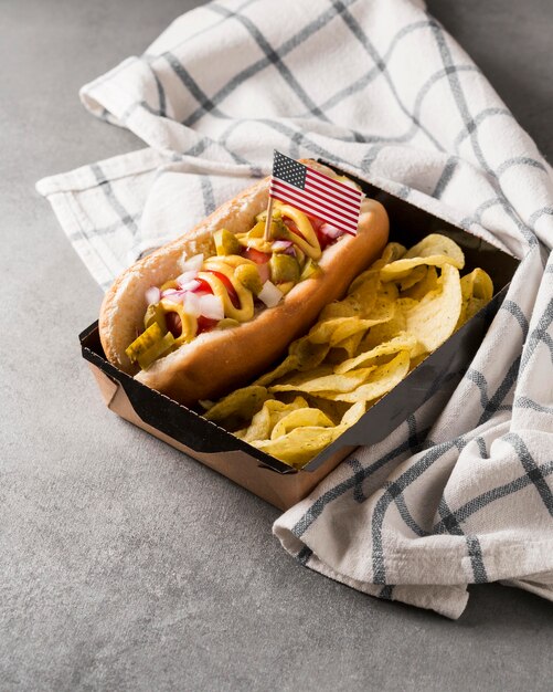 Hot-dog de alto ángulo y patatas fritas con bandera americana