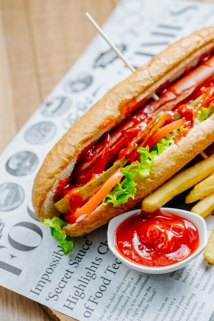 Hot dog servido con papas fritas y salsa de tomate