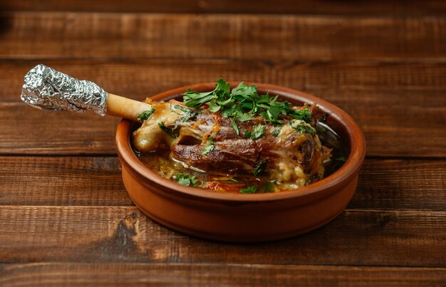 Hueso de cordero salteado en caldo de huesos con hierbas y salsa de tomate