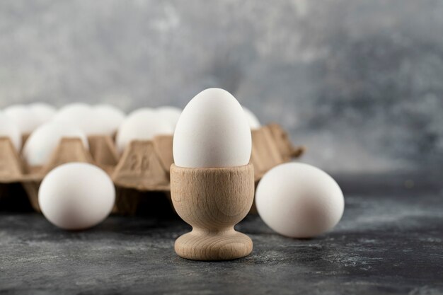 Una huevera de madera con huevo de gallina cocido.