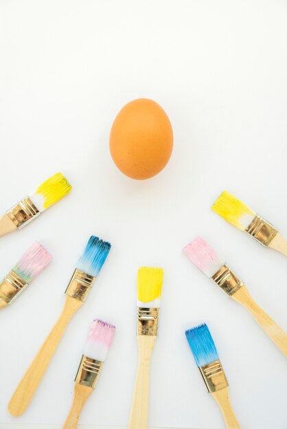 Huevo cerca de pinceles en colores