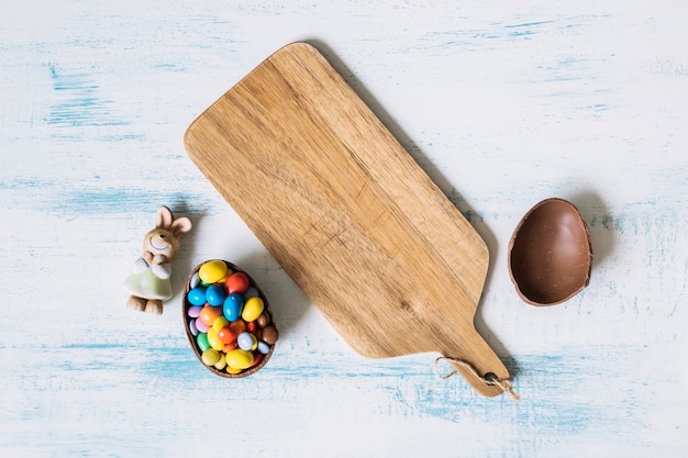 Foto gratuita huevo de chocolate y conejito cerca del tablero