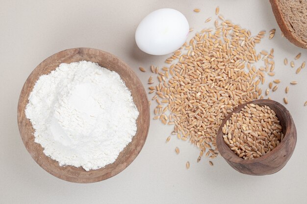 Huevo cocido con granos de avena y cuenco de madera lleno de harina