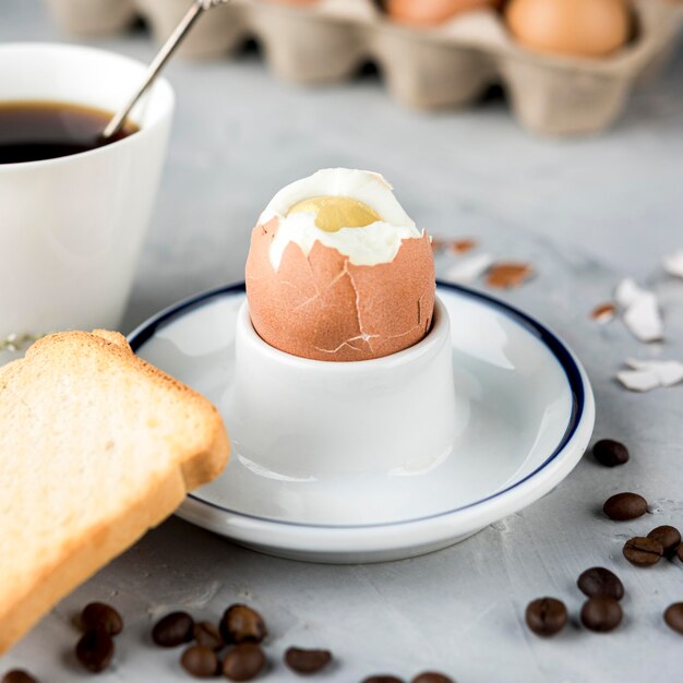 Huevo cocido con pan y granos de café.