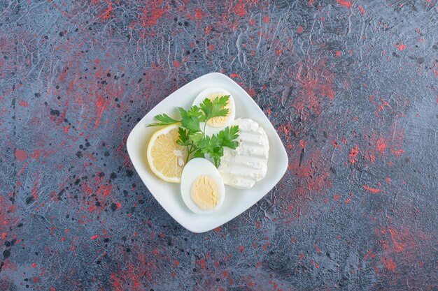 Huevo cocido con queso blanco y hierbas.