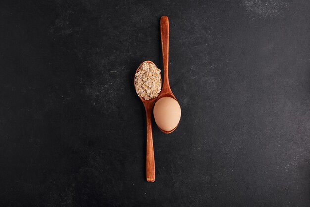 Huevo y harina en cucharas de madera, vista superior.