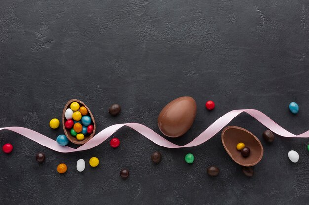 Huevo de pascua de chocolate con caramelo colorido y cinta