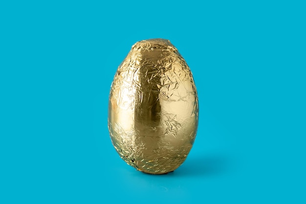 Huevo de Pascua dorado sobre fondo azul.