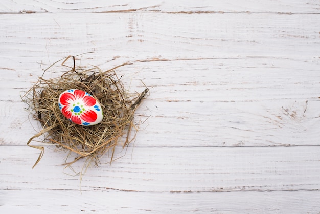 Huevo de pascua en nido sobre fondo de madera