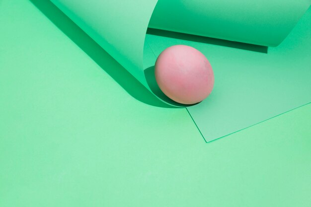 Huevo de Pascua rosa pequeño con papel enrollado.