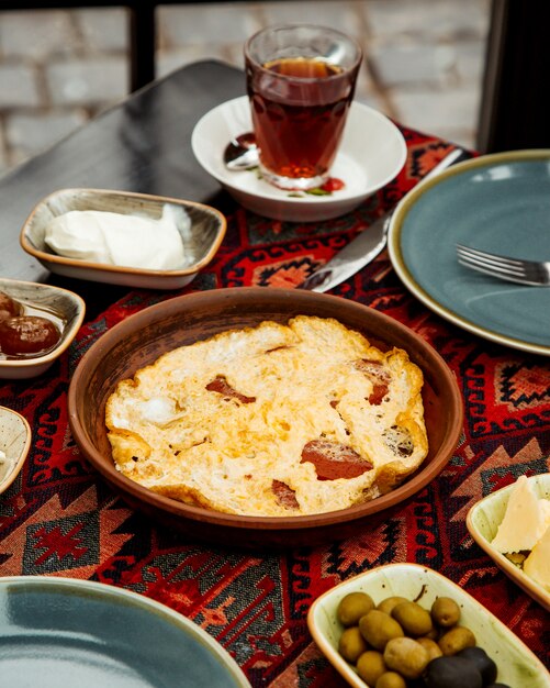 Huevo y salchicha en una cacerola de cerámica servida para el desayuno