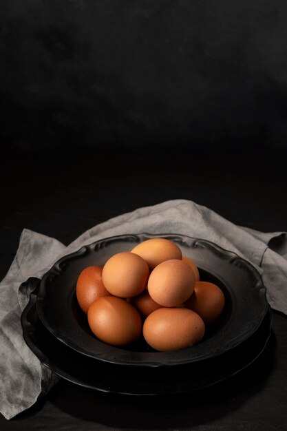 Huevos de alto ángulo en un recipiente con papel de cocina y espacio de copia