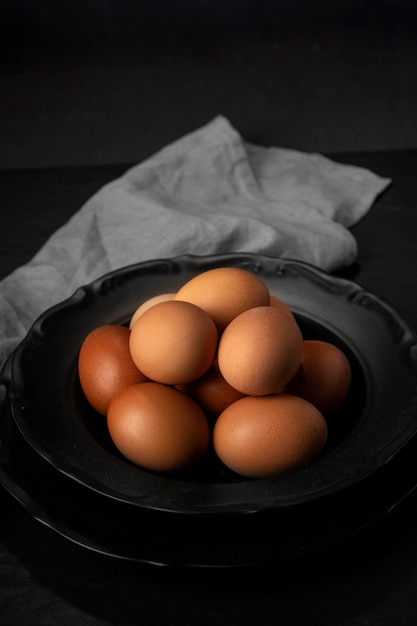 Huevos de alto ángulo en un recipiente con una toalla de cocina