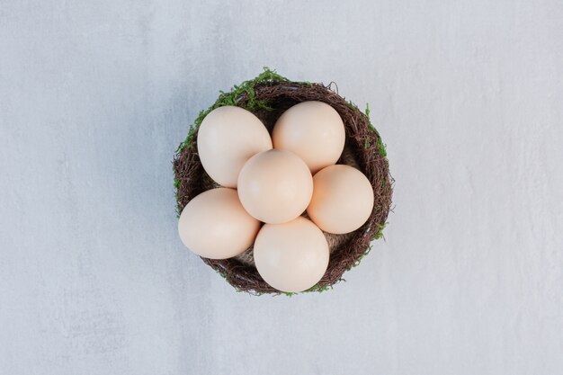 Huevos apilados en un cuenco de lujo sobre la mesa de mármol.